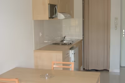 Cuisine équipée et plaques de cuisson dans un logement T3